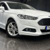 Vit Ford Mondeo Kombi 2.0 TDCi AWD Powershift, 180hk, 2019 sedan visas inomhus på ett reflekterande golv, vinklad för att visa fram och sida.